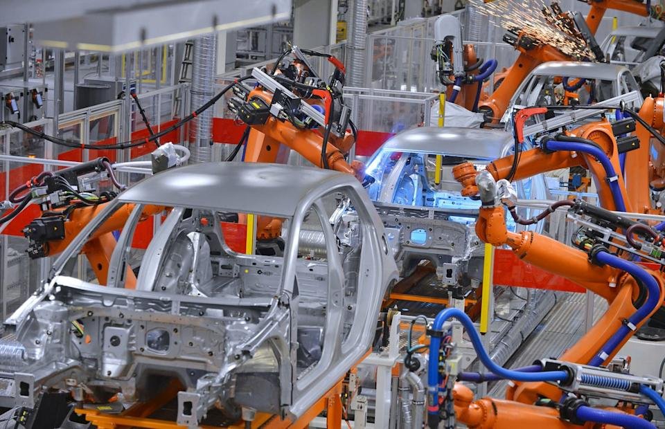 Automobiles being manufactured on an assembly line.