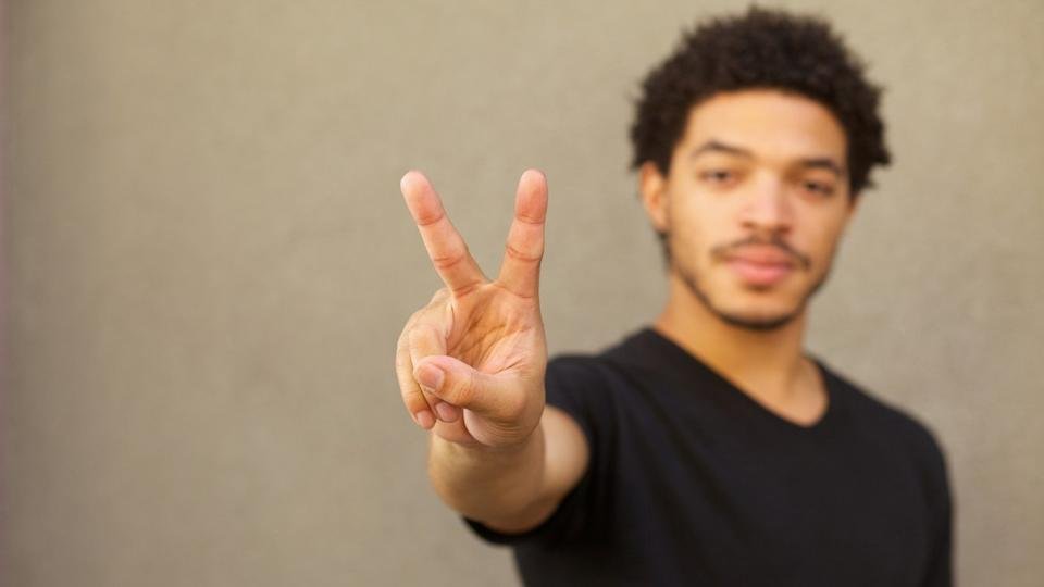 Person holding out two fingers.