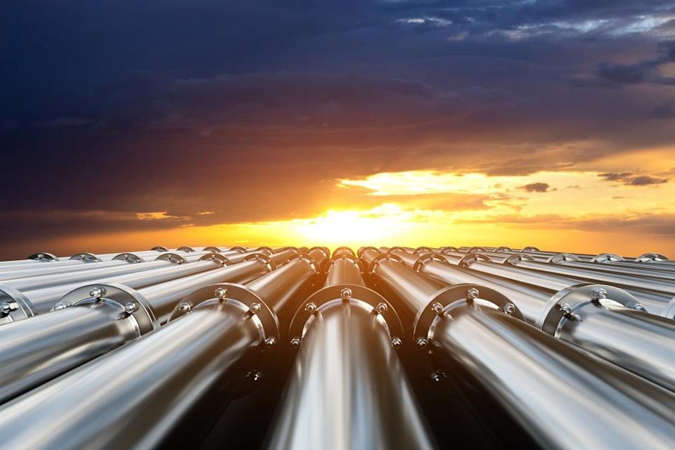 Pipelines with the sun behind the clouds in the background.