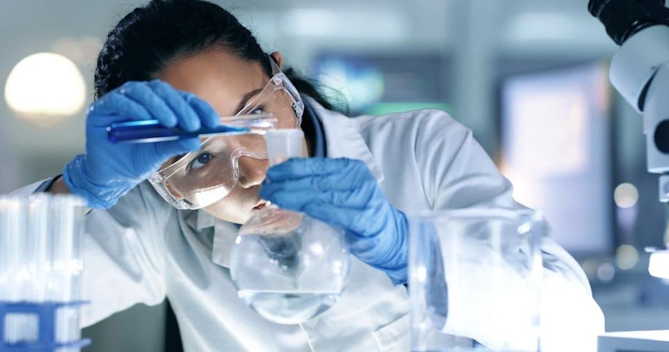 A scientist working with a flask and beaker.