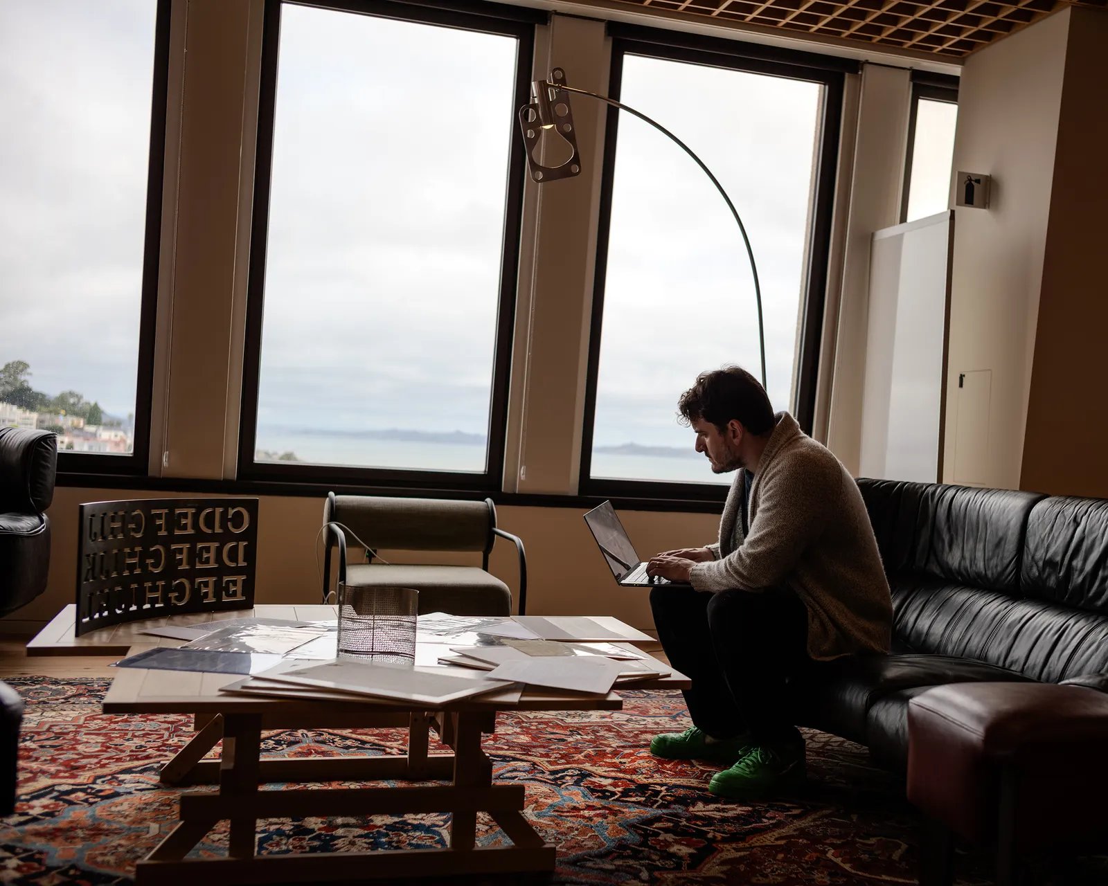 Image may contain Lamp Adult Person Chair Furniture Computer Electronics Laptop Pc Sitting Table and Floor Lamp